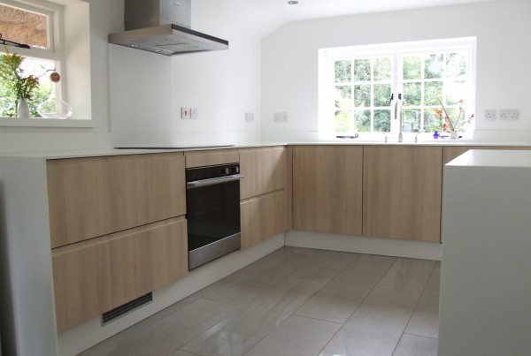 kitchen with white worktops and acacia oak panels