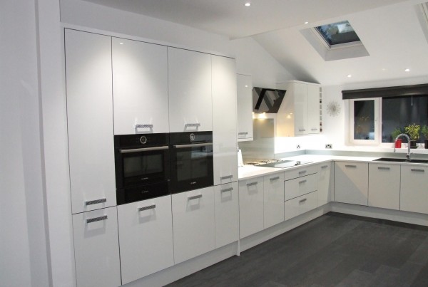 kitchen with two black ovens and white cupboards