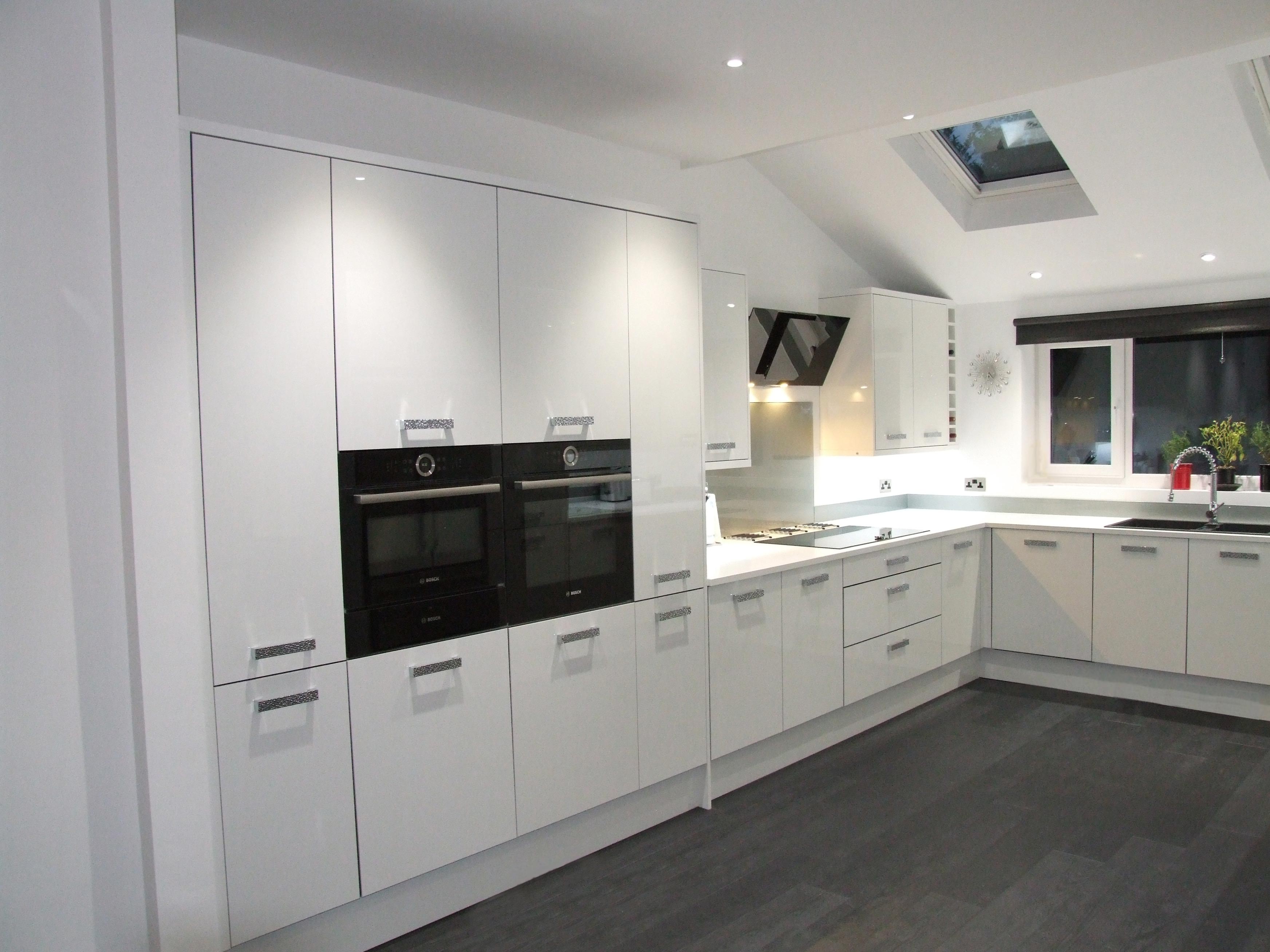 kitchen with two black ovens and white cupboards
