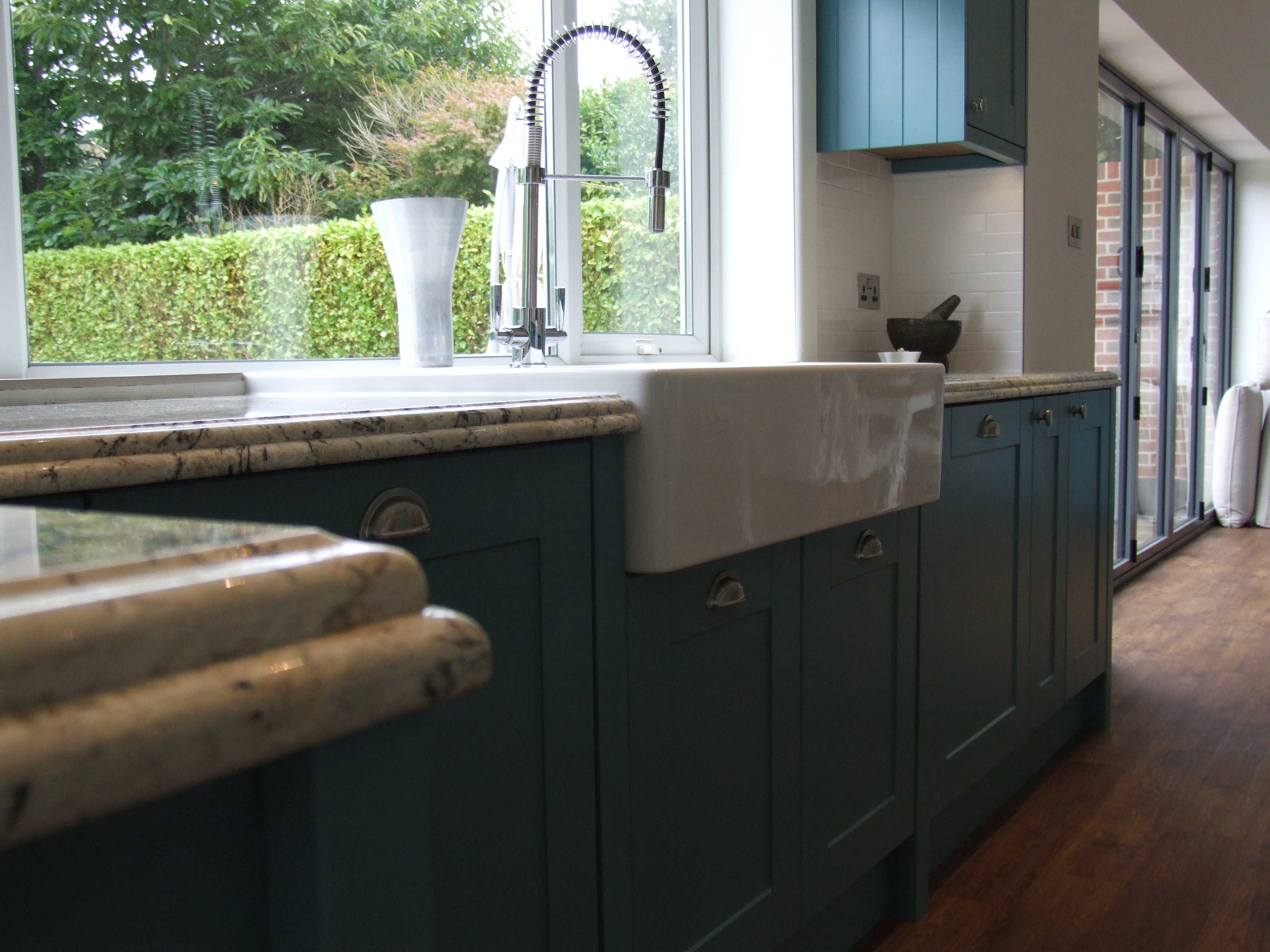 Painted teal kitchen with marble worktops